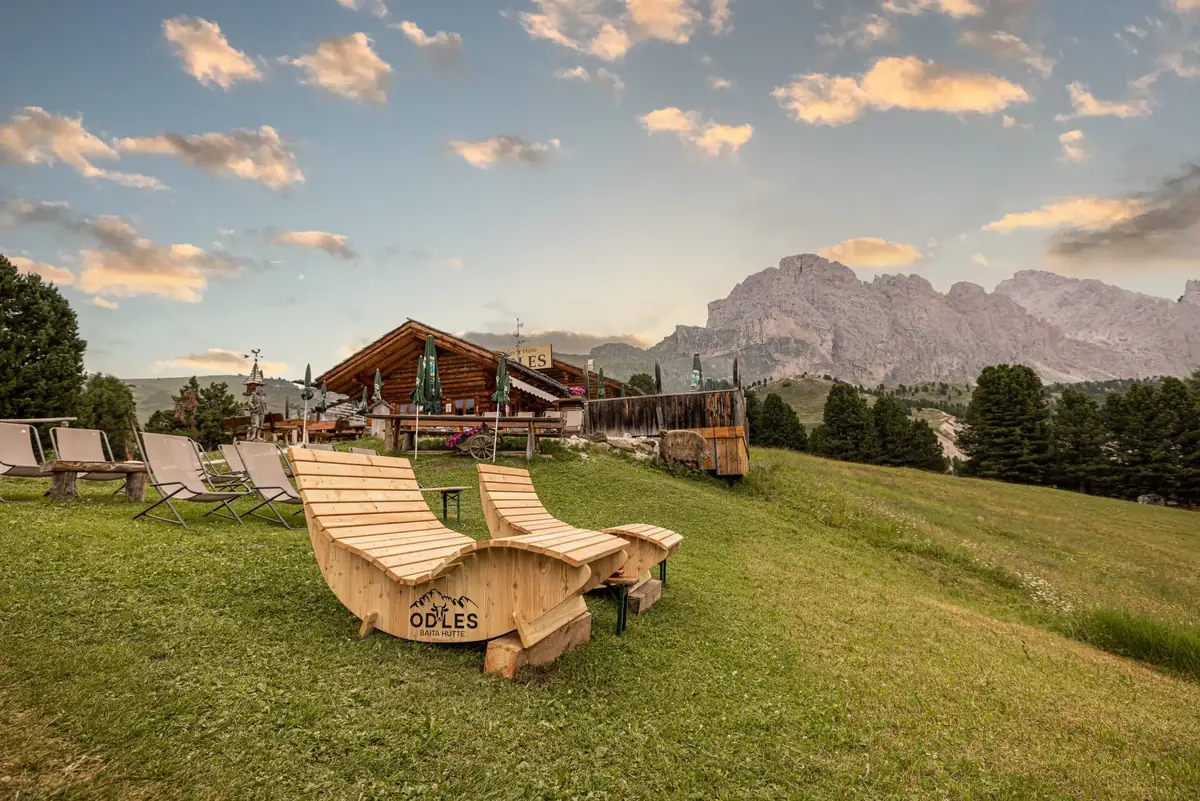 Holzliegen vor der Baita Odles mit Dolomitenpanorama