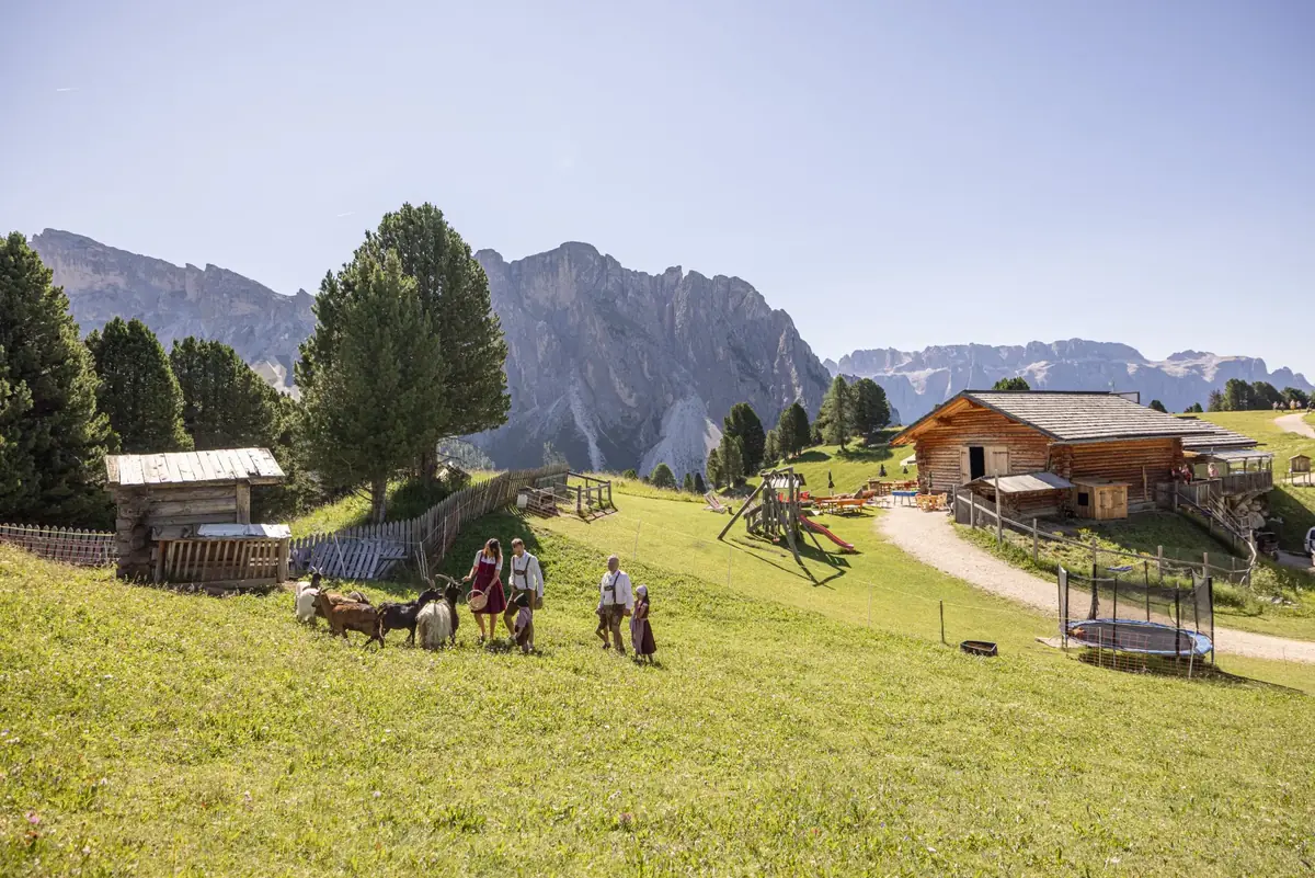 Familie mit Ziegen am Spielplatz der Baita Odles